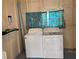Laundry room with a washer, dryer, and curtain with a fish pattern at 615 S Green Cir, Venice, FL 34285