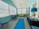 Enclosed porch features neutral carpet, blue accents, and a dining area at 615 S Green Cir, Venice, FL 34285