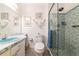 Bathroom featuring blue tiled shower, toilet, and sink with marble countertops at 6796 Gasparilla Pines Blvd # 18, Englewood, FL 34224