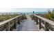 Beach access boardwalk over grassy dunes with handrails leading to a sandy beach and ocean view at 6796 Gasparilla Pines Blvd # 18, Englewood, FL 34224