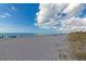Wide sandy beach on a sunny day with scattered beachgoers enjoying the ocean and clear blue sky at 6796 Gasparilla Pines Blvd # 18, Englewood, FL 34224
