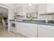 Bright kitchen features white cabinets, blue countertop, and stainless steel appliances at 6796 Gasparilla Pines Blvd # 18, Englewood, FL 34224