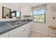 Bright kitchen with stainless steel sink, white cabinetry, and a window view at 6796 Gasparilla Pines Blvd # 18, Englewood, FL 34224