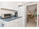 Kitchen featuring white appliances and cabinets, with a view into the living area at 6796 Gasparilla Pines Blvd # 18, Englewood, FL 34224