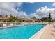 Community pool area with lounge chairs, sparkling pool and lovely landscaping at 6796 Gasparilla Pines Blvd # 18, Englewood, FL 34224