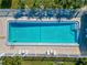Aerial view of the community pool with lounge chairs and brick paver pool deck at 6796 Gasparilla Pines Blvd # 18, Englewood, FL 34224