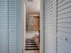 View into bathroom with tiled shower/tub behind glass door, vanity, toilet and decorative rug between closet doors at 701 Barcelona Ave # 101, Venice, FL 34285