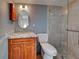 Well-lit bathroom features wood cabinets, granite counters and glass enclosed shower at 701 Barcelona Ave # 101, Venice, FL 34285