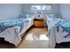Relaxing bedroom featuring twin beds with turtle patterned comforters and hardwood floors at 701 Barcelona Ave # 101, Venice, FL 34285