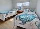 Relaxing bedroom featuring twin beds with turtle patterned comforters and hardwood floors at 701 Barcelona Ave # 101, Venice, FL 34285
