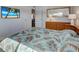Comfortable bedroom featuring a palm leaf patterned bedspread and entertainment center at 701 Barcelona Ave # 101, Venice, FL 34285