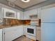 Efficient kitchen featuring granite counters, white cabinetry, and ample lighting at 701 Barcelona Ave # 101, Venice, FL 34285