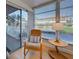 Bright patio room with comfortable chair, table, windows with sun-filtering blinds and a view of the exterior at 701 Barcelona Ave # 101, Venice, FL 34285
