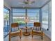 Cozy patio room with hardwood floors, chairs with decorative pillows and sun-filtering blinds on the many windows at 701 Barcelona Ave # 101, Venice, FL 34285
