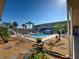 Community pool with lounge chairs, picnic tables, shady umbrellas and lush landscaping at 701 Barcelona Ave # 101, Venice, FL 34285