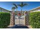 Gated entrance to a shared pool and courtyard, surrounded by lush hedges and decorative concrete walls at 701 Barcelona Ave # 101, Venice, FL 34285