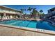 Community pool area featuring lounge chairs, picnic tables, and shady umbrellas at 701 Barcelona Ave # 101, Venice, FL 34285