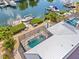 Aerial view of the backyard featuring a pool, dock, firepit, and canal frontage at 731 Flamingo Dr, Apollo Beach, FL 33572