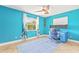 Bright blue bedroom featuring a ceiling fan, and an office setup near the window at 731 Flamingo Dr, Apollo Beach, FL 33572