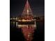 A boat adorned with festive Christmas lights cruising along the water at night at 731 Flamingo Dr, Apollo Beach, FL 33572