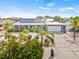 Charming single-story brick home with a metal roof and solar panels, complemented by lush landscaping and a spacious driveway at 731 Flamingo Dr, Apollo Beach, FL 33572