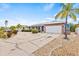 Well-maintained one-story home with a brick exterior, lush landscaping, and a large driveway leading to a two-car garage at 731 Flamingo Dr, Apollo Beach, FL 33572