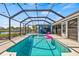 Relaxing pool area with a pink flamingo floatie, grilling area, and views of the canal at 731 Flamingo Dr, Apollo Beach, FL 33572
