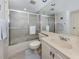 Bathroom featuring a shower with glass doors, a vanity, and neutral decor, blending style with functionality at 800 Capri Isles Blvd # 124, Venice, FL 34292