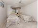 Cozy bedroom featuring twin beds, neutral walls, and a ceiling fan for comfortable living at 800 Capri Isles Blvd # 124, Venice, FL 34292