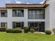 Exterior of a multi-story white building with large windows, a balcony, and well-manicured landscaping at 800 Capri Isles Blvd # 124, Venice, FL 34292