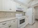 Kitchen features white appliances, cabinets and countertops at 800 Capri Isles Blvd # 124, Venice, FL 34292
