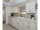 Bright kitchen with tiled floor and white cabinets at 800 Capri Isles Blvd # 124, Venice, FL 34292