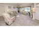 Bright living room featuring neutral décor, plush carpeting, and a picturesque view at 800 Capri Isles Blvd # 124, Venice, FL 34292