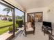 Enclosed patio with wicker chair, view of lawn and swimming pool at 800 Capri Isles Blvd # 124, Venice, FL 34292