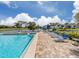 Community pool with lounge chairs and serene view at 800 Capri Isles Blvd # 124, Venice, FL 34292