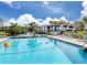 Community pool with lounge chairs and scenic views at 800 Capri Isles Blvd # 124, Venice, FL 34292