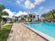 Community pool with lounge chairs and mature landscaping at 800 Capri Isles Blvd # 124, Venice, FL 34292
