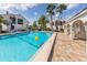 Community pool with a lounging area and tropical landscaping at 800 Capri Isles Blvd # 124, Venice, FL 34292