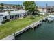 Aerial view of a home with a well-maintained lawn, dock, and boat on a canal at 832 Whitecap Cir # 5, Venice, FL 34285