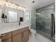 Well-lit bathroom with a marble countertop vanity and a shower with unique blue tiling at 832 Whitecap Cir # 5, Venice, FL 34285