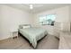 A cozy bedroom featuring a comfortable bed with a soft green patterned comforter and water views at 832 Whitecap Cir # 5, Venice, FL 34285