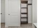 Open closet with natural wood shelving and sliding door at 832 Whitecap Cir # 5, Venice, FL 34285