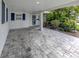 Spacious covered parking area with brick pavers and tropical landscaping at 832 Whitecap Cir # 5, Venice, FL 34285