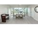 Light filled dining room with large windows and a glass dining table set for six at 832 Whitecap Cir # 5, Venice, FL 34285