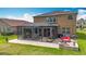 Spacious backyard featuring a screened-in porch, brick firepit, and lush green lawn at 9019 39Th Street Cir E, Parrish, FL 34219