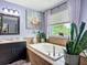 Stylish bathroom features a soaking tub, large window with natural light, and decorative accents and plants at 9019 39Th Street Cir E, Parrish, FL 34219
