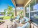 Cozy covered porch with comfortable seating and vibrant greenery, perfect for enjoying the outdoors in style at 9019 39Th Street Cir E, Parrish, FL 34219