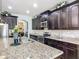 Gourmet kitchen with granite countertops, stainless steel appliances, and elegant dark wood cabinetry for storage at 9019 39Th Street Cir E, Parrish, FL 34219
