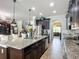 Open kitchen with island and stainless steel appliances is adjacent to the dining area and living room at 9019 39Th Street Cir E, Parrish, FL 34219