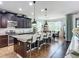 Open-concept kitchen features a center island with bar stools, dark cabinetry, and access to the dining area at 9019 39Th Street Cir E, Parrish, FL 34219